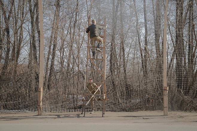 우크라이나 군인들이 지난달 10일(현지시간) 하르키우주 이지움시 입구에 드론 공격을 막기 위한 방어용 그물을 설치하고 있다. AFP=연합뉴스