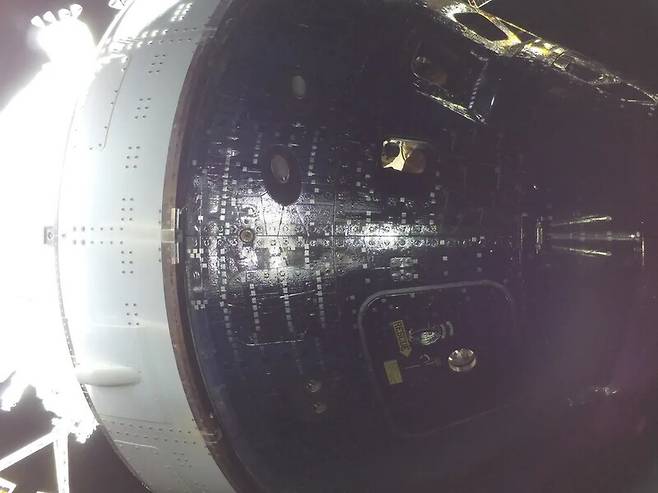 지구인 여러분 안녕! 지구로 돌아오고 있는 아르테미스 2호 우주선의 창을 통해, 우주비행사 크리스티나 코크가 무중력 표시기 라이즈 인형을 가리키며 미소 짓고 있는 모습이 보인다. 우주선 태양전지판 끝에 부착된 고프로 카메라로 9일 촬영한 사진이다. 미국항공우주국 제공