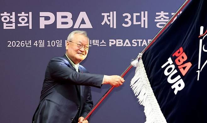 윤영달 프로당구협회(PBA) 신임 총재가 10일 경기도 고양시 킨텍스 PBA 스타디움에서 취임식을 열고 PBA 깃발을 흔들고 있다. PBA 제공