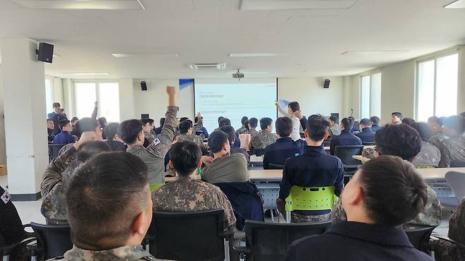 김은경 신용회복위원장이 7일 경기 화성시 남양지역의 한 공군부대에서 공군을 대상으로 신용관리 교육을 진행하고 있다. 강연에 참석한 군인들이 퀴즈를 맞히기 위해 손을 드는 모습. 정호원 기자