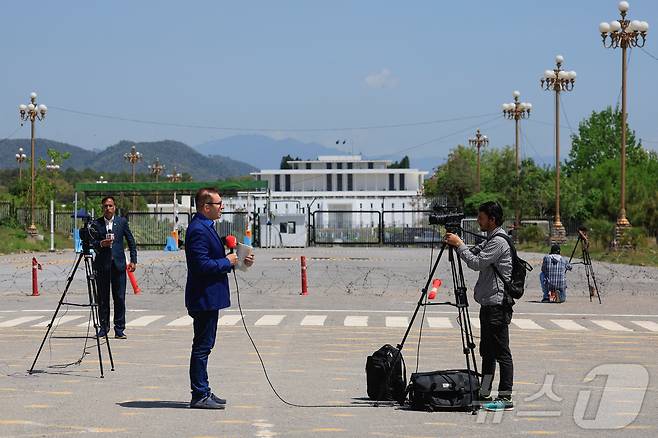 미국·이란 간 평화회담을 하루 앞둔 10일(현지시간) 파키스탄 이슬라마바드에서 취재진이 대통령 관저를 배경으로 취재하고 있다. 2026.04.10. ⓒ 로이터=뉴스1