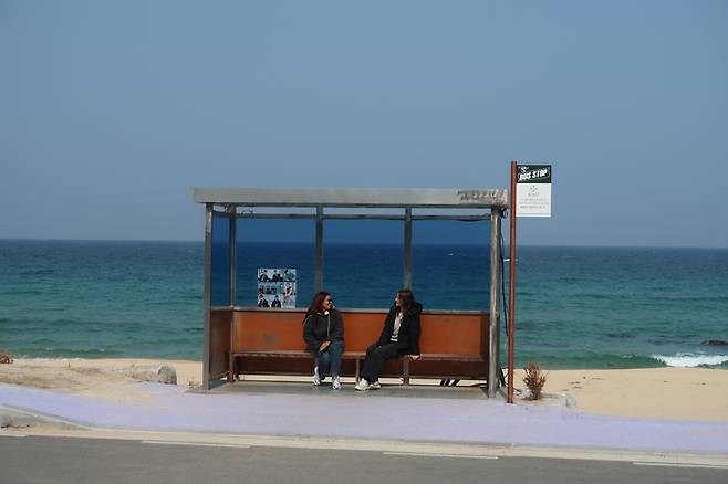 강릉 향호해변에 위치한 BTS 버스정류장에서 사진을 찍는 외국인 관광객/사진=김지은 여행+ 기자