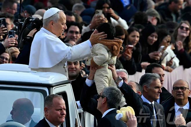 레오 14세 교황이 바티칸 성 베드로 광장에서 한 어린이를 축복하고 있다. 2025.12.17. ⓒ AFP=뉴스1