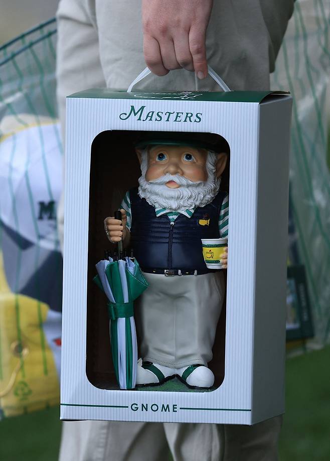 미국 조지아주 오거스타의 오거스타 내셔널 골프클럽에서 열린 2026 마스터스 토너먼트 연습 라운드에서 한 관람객이 노움 인형을 들고 이동하고 있다. AFP