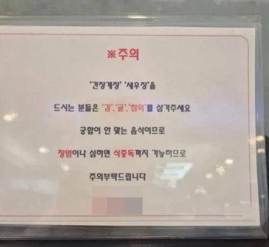 한 초밥 뷔페에 붙은 경고문. 게장을 먹은 후 감, 귤, 참외 등을 섭취하지 말라고 설명하고 있다. (출처=온라인 커뮤니티)
