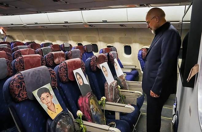 모하마드 바게르 갈리바프 이란 의회 의장이 파키스탄 이슬라마바드로 이동하는 기내에서 공습으로 사망한 초등학교 학생들의 영정사진을 바라보고 있다. AFP연합뉴스
