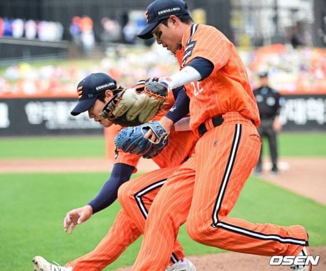 채은성(오른쪽)과 이상규가 3루 주자의 득점을 막기 위해 실책 후 흐른 공을 포구하기 위해 함께 달려들고 있다.