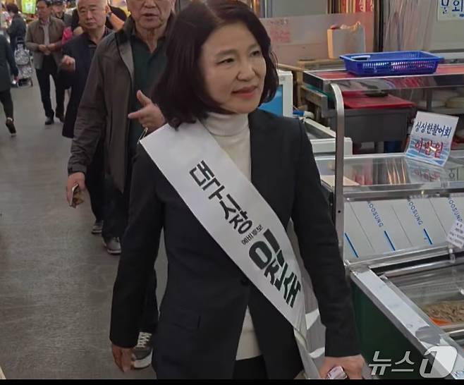 이진숙 전 방송통신위원장이 지난 12일 '대구시장 예비후보 이진숙' 이라는 어깨띠를 하고 전통시장을 누비며 지지를 호소하는 모습. (SNS 갈무리) ⓒ 뉴스1