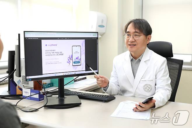 이강준 인제대 일산백병원 정신건강의학과 교수가 외래 진료실에서 환자에게 모바일 기반 인지중재 치료 프로그램 '코그테라'의 주요 기능과 기대 효과를 안내하고 있다.(인제대 일산백병원 제공)