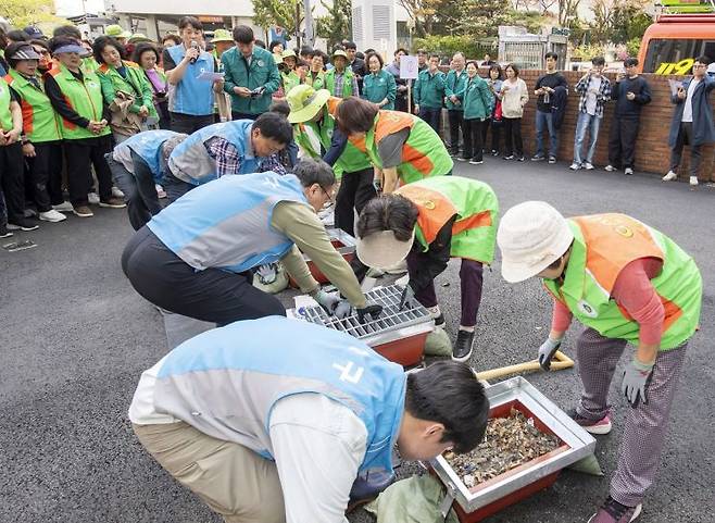 풍수해 대비 종합훈련에 참가한 주민들이 불법 덮개를 씌운 빗물받이를 열어 내부 오물을 걷어내고 있다. 용산구 제공.