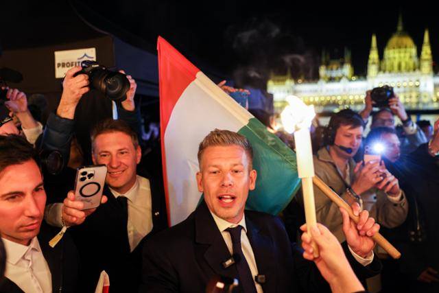 12일 치러진 헝가리 총선에서 승리한 티서당의 대표 마자르 페테르가 수도 부다페스트 다뉴브 강변에 마련된 축하무대로 이동하며 취재진 질문에 답하고 있다. 부다페스트=타스 연합뉴스