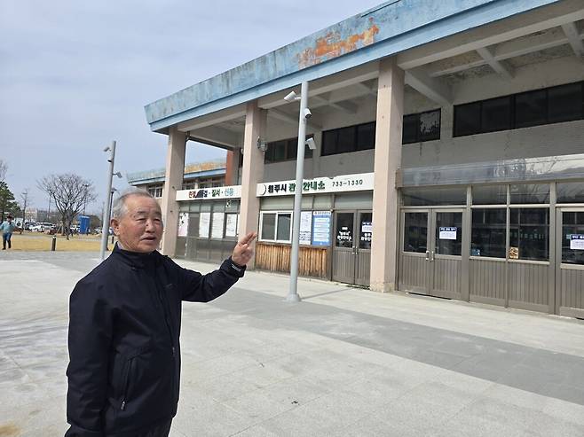 황승룡 원주 중앙동 12통장이 구 원주역에서 역사를 가리키며 지역 현황을 설명하고 있다.