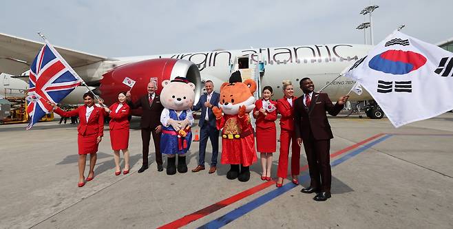 Crew members pose for a commemorative photo in front of a Virgin Atlantic aircraft arriving at the parking stand of Incheon Airport Terminal 2 on Tuesday, celebrating the launch of the Incheon-London route. (Joint press corps)