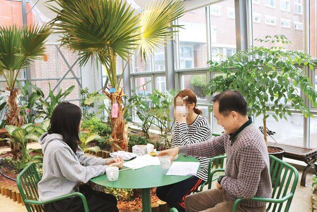 지난 6일 광주광역시 일곡중에 학교복합시설로 조성된 온실인 ‘호프 가든’에서 비를 피해 들어온 학생들과 김주신 교장이 대화하고 있다. 이 시설은 주민에게는 쉼터로, 학생에게는 교육장으로 활용되고 있다. 광주=이도경 기자