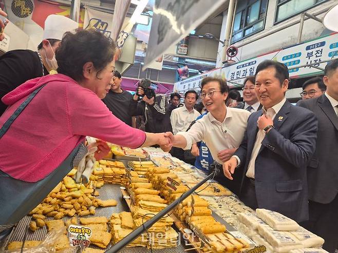 부산진구 부전시장에서 가게를 운영하는 한 상인이 전재수 민주당 부산시장 후보와 악수를 하고 있다.ⓒ데일리안 허찬영 기자