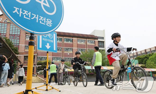 자전거의 날인 22일 경기 수원시 권선구 명당초등학교에서 열린 '2026년 찾아가는 자전거&PM(개인형 이동장치) 안전교육'에서 학생들이 교통표지판과 법규 등 안전 주행 방법을 '자전거와환경 사회적협동조합' 관계자들에게 교육받고 있다. 2026.4.22 ⓒ 뉴스1 김영운 기자