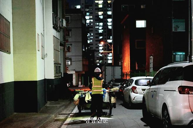 지난 26일 인천 부평구에서 환경미화원이 리어카를 끌고서 밤거리를 지나가고 있다. 우혜림 기자