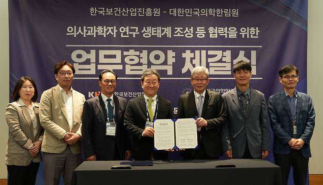 한국보건산업진흥원과 대한민국의학한림원이 30일 서울 코엑스에서 의사과학자 연구 생태계 조성을 위한 업무협약을 체결했다. 관게자들이 기념촬영하는 모숩./사진=국보건산업진흥원