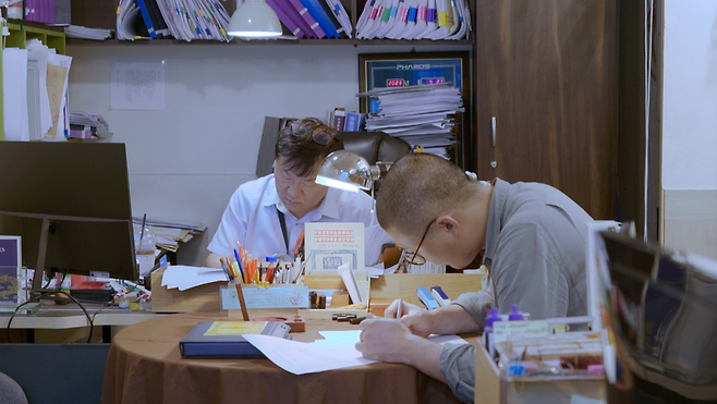 제27회 전주국제영화제 한국경쟁부문에 진출한 다큐멘터리 <회생>의 한 장면. 법무사 아버지 김충관씨(왼쪽)과 사무원이자 감독 김면우씨. 전주국제영화제 제공