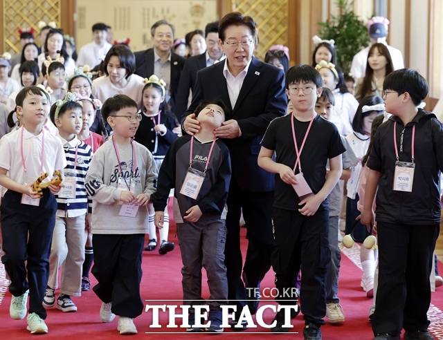 이재명 대통령이 5일 어린이날을 맞아 개최한 '어서 와, 청와대는 처음이지' 행사에서 아이들과 함께 이동하고 있다. /뉴시스