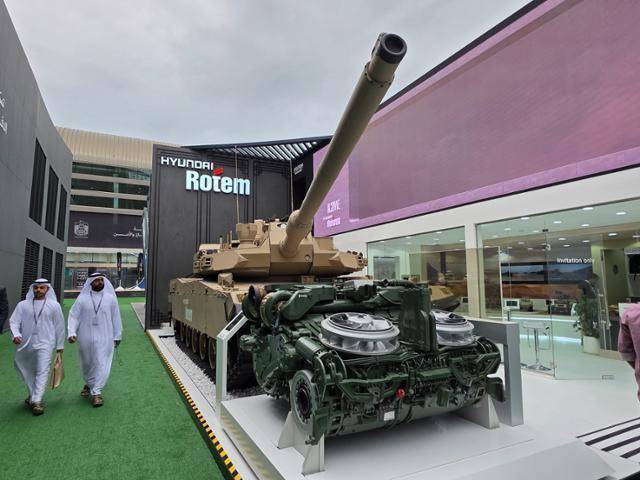 지난해 UAE 아부다비에서 열린 'IDEX 2025 국제방산전시회'에서 현대로템 야외 부스에 중동형 K2전차(K2ME)와 국산파워팩이 전시돼 있다. SNT다이내믹스 제공