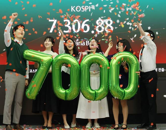 코스피가 7천을 돌파한 6일 서울 중구 하나은행 본점 딜링룸에서 직원들이 축하 세리머니를 하고 있다. 연합뉴스
