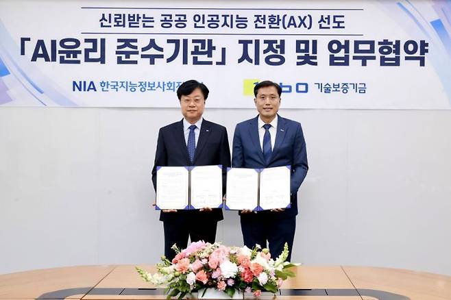 박주선 기보 전무이사(오른쪽)와 김형철 한국지능정보사회진흥원장이 대구 동구 한국지능정보사회진흥원(NIA) 본원에서 업무협약 후 기념촬영을 하고 있다. 기보