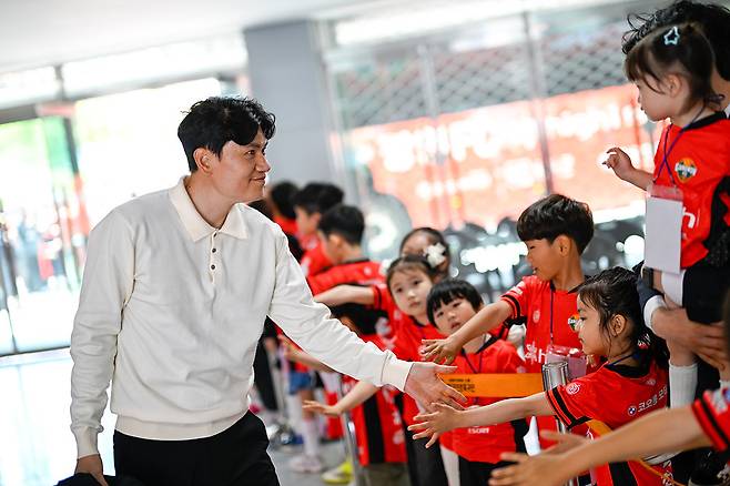 정경호 강원FC 감독(왼쪽)이 4월 25일 강원 강릉의 강릉하이원아레나에서 열린 FC서울과의 홈경기 전 에스코트 키드들과 하이파이브를 하고 있다. 사진 제공=강원FC