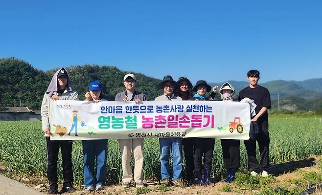 영천시 새마을체육과 직원들이 농촌 일손돕기에 참여한 뒤 기념사진을 찍고 있다. ⓒ영천시 제공