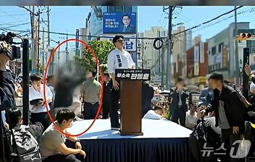 지난 9일 부산 북구 구포시장 인근 쌈지공원에서 열린 한동훈 후보 출마 기자회견 모습을 담으려던 방송사 카메라 기자가 뒷걸음치다 떨어지는 장면. (유튜브 갈무리) ⓒ 뉴스1