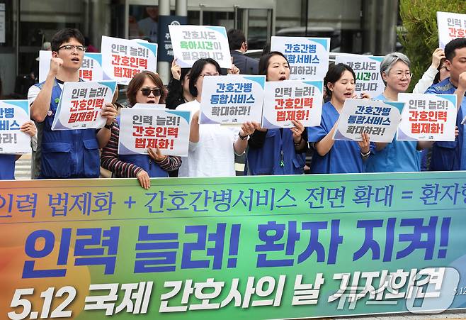 공공운수노조 의료연대본부와 행동하는 간호사회 회원들이 12일 서울 종로구 서울대학교병원 본관 앞에서 열린 '인력 늘려! 환자 지켜! 5.12 국제 간호사의 날 기자회견'에서 간호 인력 충원 및 법제화, 간호·간병통합서비스 전면 확대, 교대제 간호사의 육아기 근로시간 단축 사용 등을 촉구하며 구호를 외치고 있다. 2026.5.12 ⓒ 뉴스1 임지훈 인턴기자