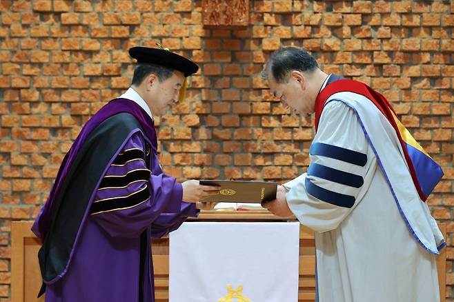 김운성 영락교회 담임목사가 12일 서울 광진구 장로회신학대학교 한경직기념예배당에서 박경수 장신대 총장으로부터 명예신학박사 학위를 수여받고 있다. 사진=서동일 기자