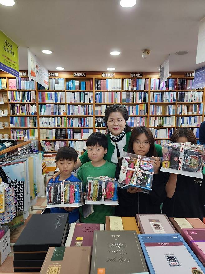 김영희(가운데) 전남 여수 크리스챤백화점 대표가 지난 4일 ‘한 셈 치고’ 캠페인으로 매장을 찾은 어린이에게 책과 어린이날 선물을 전한 뒤 기념사진을 찍고 있다. 여수 크리스챤백화점 제공