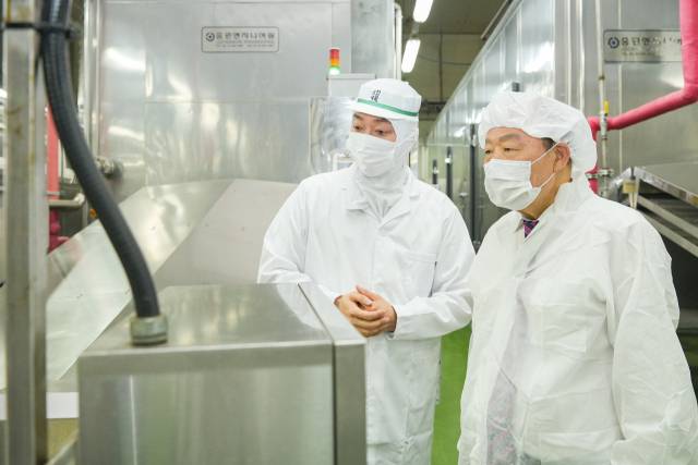 부산상공회의소 양재생(왼쪽) 회장이 13일 부산 사하구 삼진식품 장림 공장에서 박용준 대표와 공장 시설을 둘러보고 있다. 부산상공회의소 제공