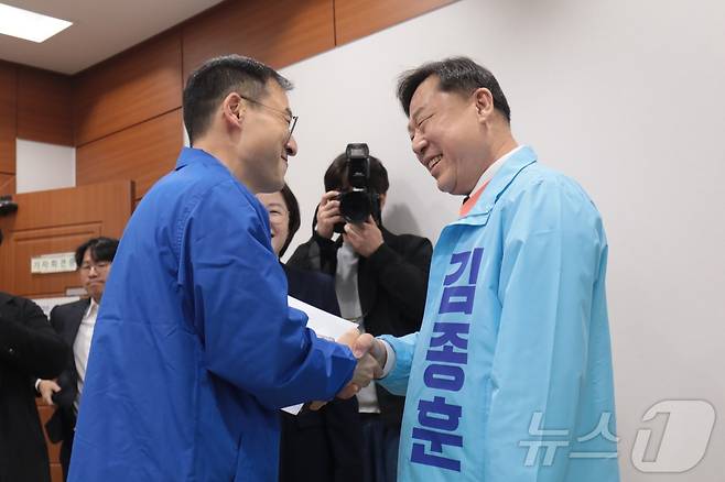 울산시장 선거에 나서는 더불어민주당 김상욱 의원과 진보당 김종훈 전 동구청장이 지난 3월 25일 울산시의회 프레스센터에서 만나 악수하고 있다. 2026.3.25 ⓒ 뉴스1 김세은 기자