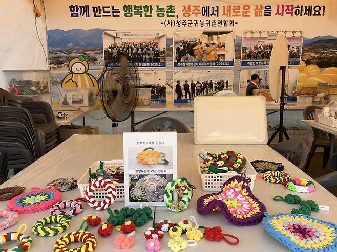 ▲ (사)성주군귀농귀촌연합회가 운영하고 있는 '참외꽃 코사지 만들기' 체험부스.김정수 기자