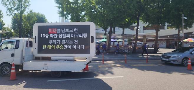 14일 잠실 야구장 인근에 LG 손주영의 마무리 전환을 비판하는 문구가 적힌 시위 트럭이 서 있다.