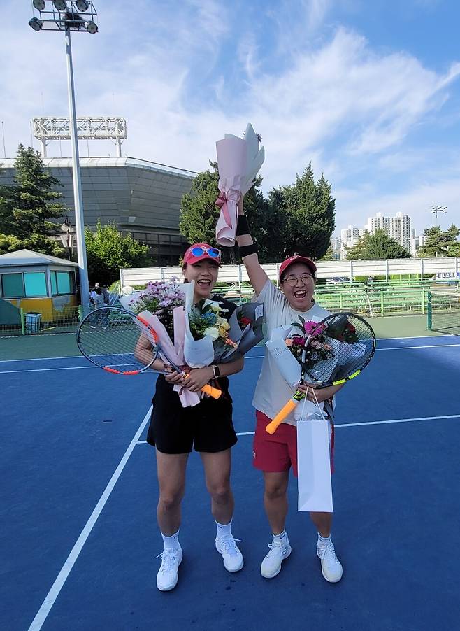 서울컵 개나리부 정상에 오른 김유리 주임(오른쪽)이 파트너인 후배 김민주 씨와 환호하고 있다. 대한테니스협회 인사 회계팀에서 회계업무를 맡고 있는 김 주임은 퇴근 후에는 라켓을 놓지 않는 열성 생활체육 동호인이다. 김종석
