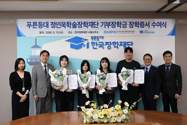 지난 13일 한국장학재단 서울사무소에서 열린 ‘푸른등대 기부장학금 장학증서 수여식’에서 유용재 정인욱학술장학재단 사무국장(왼쪽에서 두 번째)과 박단호 청년지원본부장(오른쪽에서 두 번째)이 장학생들과 기념 촬영을 하고 있다. 삼표그룹