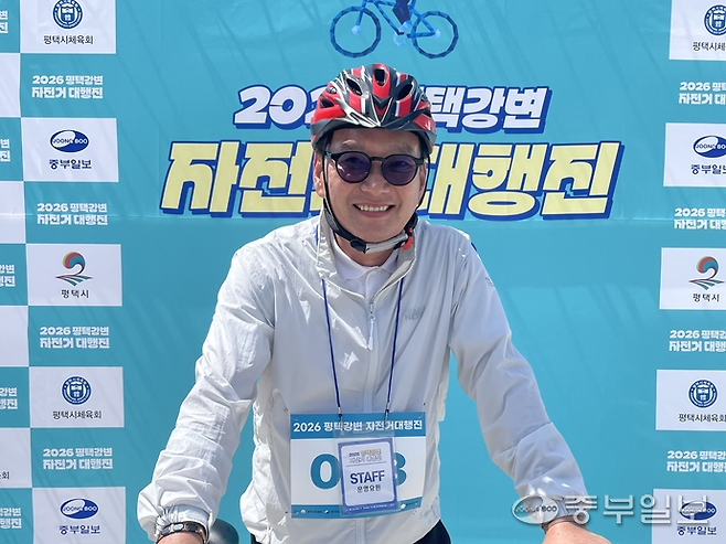 박종근 평택시체육회장이 지난 16일 '2026 평택강변 자전거 대행진' 행사장 포토존에서 자전거를 잡고 활짝 웃는다. 조미림 기자