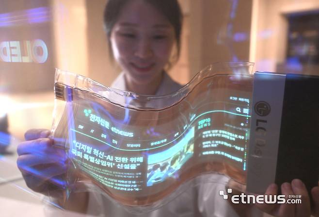 본격적인 인공지능(AI) 시대를 위한 디스플레이의 기술력은 중요하다. AI 등 신기술이 차세대 디스플레이에 적용되면 영화처럼 피부에 접착하거나 웨어러블, 모빌리티 등 일상생활과 다양한 분야에 활용 가능하다. 24일 서울 강서구 LG디스플레이 쇼룸에서 연구원이 어떤 형태로든 자유롭게 바꿀 수 있고 고해상도와 풀컬러를 구현한 스트레처블 디스플레이로 전자신문 기사를 보고 있다. 박지호기자 jihopress@etnews.com