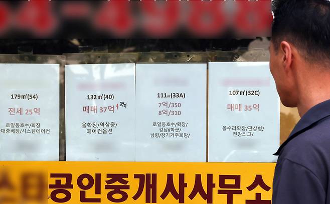 한 시민이 17일 서울 강남구 부동산 중개업소에 붙은 매매·전세·월세 매물 안내문을 보고 있다. 연합뉴스