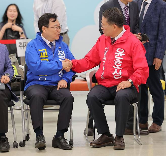지난 14일 서울 종로구 서울시선거관리위원회에서 서울교육감에 도전하는 정근식(왼쪽)·윤호상 후보가 제9회 전국동시지방선거 교육감 후보 등록 전 악수하고 있다. 연합뉴스
