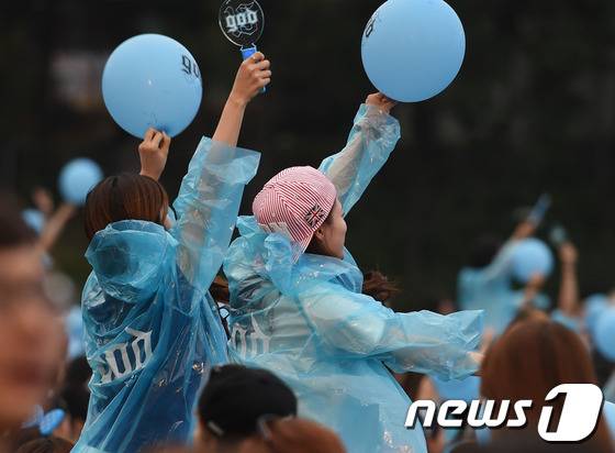 ‘지오디 15주년 애니버서리 리유니온 콘서트'에서 파랑색 우비를 입은 여성팬들이 하늘색 풍선을 들고 god를 응원하고 있다.ⓒ 뉴스1