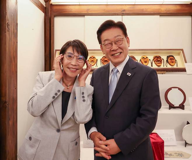 이재명 대통령과 다카이치 사나에 일본 총리가 19일 경북 안동에서 열린 친교행사에서 기념촬영을 하고 있다. 일본 내각 공보실 공식 계정은 "대통령이 벗어 둔 원래 쓰고 있던 안경을 재빨리 빌려 쓰고는… 찰칵"이라는 설명을 달았다. /x