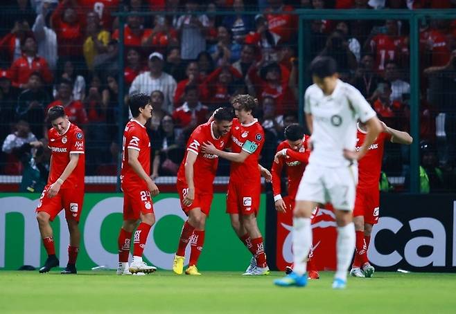 CONCACAF 챔피언스컵 - 준결승 2차전 - 톨루카 대 로스앤젤레스 FC - 에스타디오 네메시오 디에스, 톨루카, 멕시코 - 2026년 5월 6일. 톨루카의 파울리뉴가 네 번째 골을 넣은 후 동료들과 함께 기뻐하고 있고, 로스앤젤레스 FC의 손흥민은 실망한 표정을 짓고 있다. 로이터연합뉴스