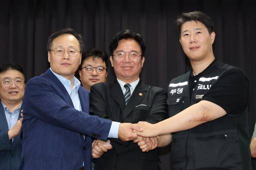 지난 20일 경기 수원시 장안구 경기고용노동청에서 열린 삼성전자 임금협상을 마친 후 여명구 삼성전자 DS(디바이스솔루션·반도체 사업 담당) 피플팀장(왼쪽부터)과 김영훈 고용노동부 장관, 최승호 삼성그룹 초기업노동조합 삼성전자지부 위원장이 잠정 합의한에 서명한 후 손을 맞잡고 있다. /뉴시스