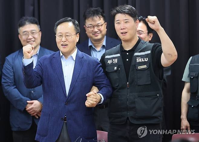 20일 경기도 수원시 장안구 경기고용노동청에서 열린 삼성전자 임금협상을 마친 후 여명구 삼성전자 DS(디바이스솔루션·반도체 사업 담당) 피플팀장과 최승호 삼성그룹 초기업노동조합 삼성전자지부 위원장이 잠정 합의안에 서명한 후 파이팅을 외치고 있다. 사진=연합뉴스 제공
