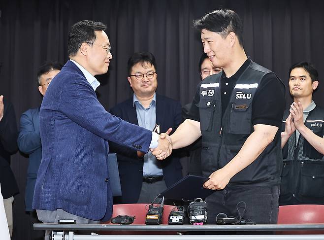 20일 경기도 수원시 장안구 경기고용노동청에서 열린 삼성전자 임금협상을 마친 후 여명구 삼성전자 DS(디바이스솔루션·반도체 사업 담당) 피플팀장과 최승호 삼성그룹 초기업노동조합 삼성전자지부 위원장이 잠정 합의안에 서명한 후 악수하고 있다. ⓒ 연합뉴스