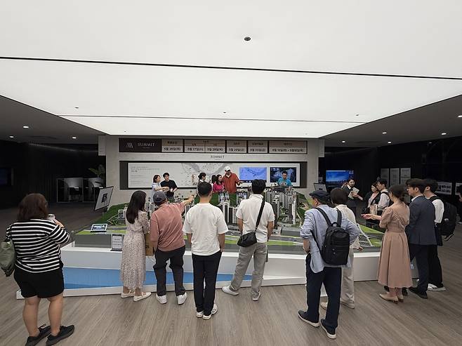 지난 22일 서울 강남구에 마련된 ‘써밋더힐’ 견본주택에서 방문객이 단지 모형도를 살펴보고 있다. 윤성현 기자